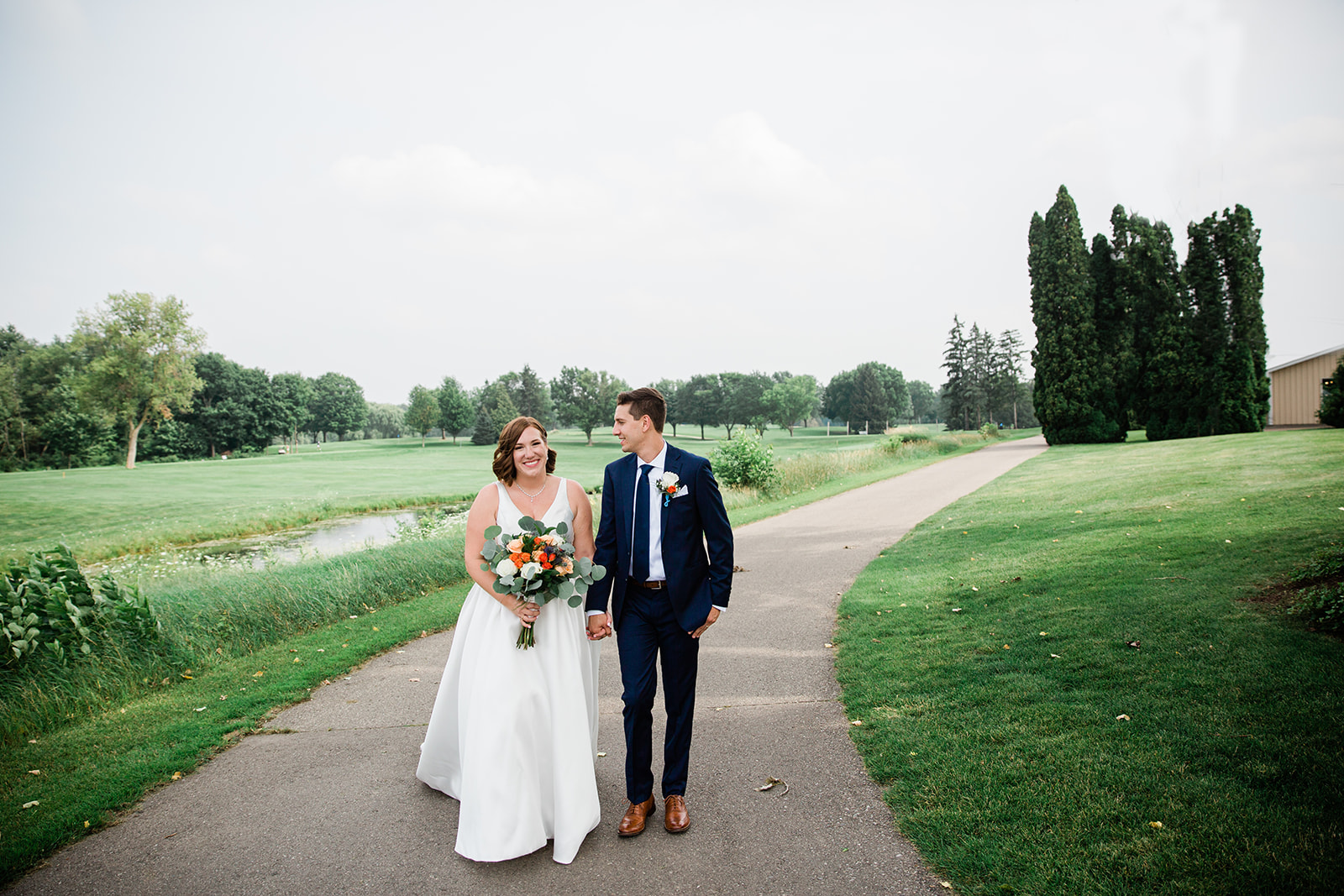 Bride and groom walking along the cart path at Foh Hills Summerhouse